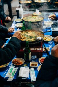Корейцы едят острый суп с морепродуктами и пьют соджу