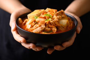 Миска горячего кимчитиге с тофу, мясом и овощами.