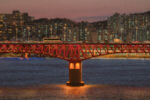 Поезд метро и автобусы на мосту через Ханган осенним вечером