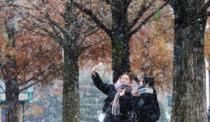 Две девушки делают селфи во время снегопада в парке в Сеуле