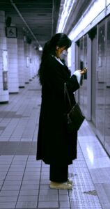 Женщина в маске ждёт поезд в метро, осенний сезон простуды