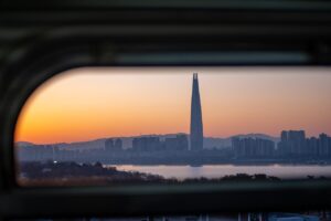 Закат над рекой Ханган и небоскрёбом Lotte World Tower, видимый из поезда сеульского метро